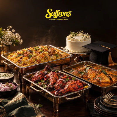 Graduation party catering Singapore: briyani, chicken tandoori and fish masala in buffet trays beside a white cake and a graduation cap