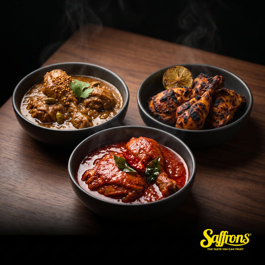 Three dark ceramic bowls side by side holding chicken masak merah in scarlet gravy, chicken masala in brown gravy and charred tandoori chicken