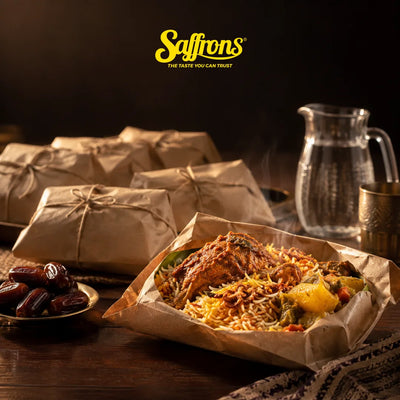 Tahlil catering Singapore: brown paper briyani packets, one opened with chicken, beside dates and a jug of water